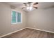 Bedroom featuring a ceiling fan, natural light from a large window with blinds and wood look flooring at 5577 Whittondale Rd, Lithonia, GA 30058