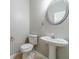 Powder room featuring pedestal sink, round mirror, and white toilet at 1346 Upshur Pl, Buford, GA 30519