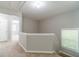 Upstairs hallway features carpeted floors and a railing overlooking the stairs at 1346 Upshur Pl, Buford, GA 30519