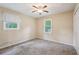 Bedroom featuring neutral carpet, a ceiling fan, closet, and two windows for natural light at 1952 Winding Creek Sw Ln, Marietta, GA 30064