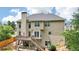 Back of a two-story house with a deck, staircase, a well-maintained backyard, and lush green trees at 2851 Weatherstone Se Cir, Conyers, GA 30094
