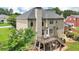 Two-story house with a deck featuring dining, staircase and a lush green yard with manicured landscaping at 2851 Weatherstone Se Cir, Conyers, GA 30094