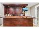 Custom basement bar with dark wood cabinetry, television, seating and recessed lighting at 2851 Weatherstone Se Cir, Conyers, GA 30094