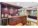 Entertainers dream with custom bar featuring wood cabinets, a sink, television and beverage cooler at 2851 Weatherstone Se Cir, Conyers, GA 30094
