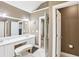 Bathroom features a double sink vanity, framed mirror, bench seat, and tile flooring at 2851 Weatherstone Se Cir, Conyers, GA 30094