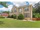 Angle-shot of a house with healthy green lawn and lush green trees with a glimpse of neighboring home at 2851 Weatherstone Se Cir, Conyers, GA 30094