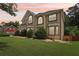 Two-story home with manicured landscaping with lush green trees, and blue-pink twilight skies at 2851 Weatherstone Se Cir, Conyers, GA 30094