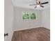 Bedroom with wood-look floors, white walls, a ceiling fan, and view to treed backyard at 4477 Timber Ridge Dr, Douglasville, GA 30135