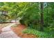 A tranquil backyard with lush greenery, a brick pathway, and a glimpse of the home's deck at 2072 Castleway Ne Dr, Atlanta, GA 30345