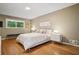 A bedroom with hardwood floors, a large window, and a queen bed with white linens at 2072 Castleway Ne Dr, Atlanta, GA 30345