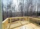 New wooden deck with railings overlooking a wooded backyard at 66 Pine Creek Ct, Dallas, GA 30157