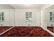 This bedroom features mirrored walls, a window with plantation shutters, and a red patterned carpet at 2983 Peek Nw Rd, Atlanta, GA 30318