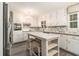 Charming kitchen with white cabinets, tile backsplash, an island with seating, and stainless steel appliances at 2983 Peek Nw Rd, Atlanta, GA 30318