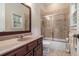 Bathroom featuring a marble-surround tub and a sleek vanity with marble countertops at 3015 Southmoor Trce, Roswell, GA 30075