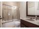 Well-lit bathroom features a vanity with a sink, a toilet, and a shower-tub with sliding glass doors at 3015 Southmoor Trce, Roswell, GA 30075