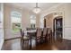 Elegant dining room features hardwood floors, wainscoting, a modern chandelier, and a large window overlooking the yard at 3015 Southmoor Trce, Roswell, GA 30075