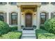 Inviting front entrance with stone columns, arched windows, lush landscaping, and a stained wood door with sidelights at 3015 Southmoor Trce, Roswell, GA 30075