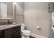 Elegant powder room with granite countertop, dark wood vanity, and decorative shelving at 3015 Southmoor Trce, Roswell, GA 30075