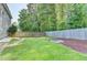 Spacious backyard with lush lawn, wooden fence, and stone fire pit area at 4845 Dartford Dr, Powder Springs, GA 30127