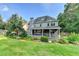 Exterior rear view of home with a covered patio and a beautifully landscaped lawn at 4845 Dartford Dr, Powder Springs, GA 30127