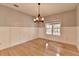 Dining room featuring hardwood floors, wainscotting, and a modern chandelier at 4845 Dartford Dr, Powder Springs, GA 30127