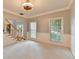 Carpeted living room with staircase, view into front door and natural light from windows at 4845 Dartford Dr, Powder Springs, GA 30127