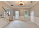 Carpeted living room with a staircase to the left and two windows letting in natural light at 4845 Dartford Dr, Powder Springs, GA 30127