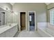 Bright main bathroom featuring dual sinks, tile floor, separate shower and tub, and plenty of storage at 4845 Dartford Dr, Powder Springs, GA 30127