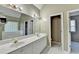 Main bathroom with dual sinks, large mirror, walk in closet, tile floor, and separate tub and shower at 4845 Dartford Dr, Powder Springs, GA 30127