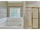 Close-up of the tub and shower featuring tile and gold accents in the main bathroom at 4845 Dartford Dr, Powder Springs, GA 30127