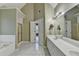 Bright main bathroom featuring dual sinks, tile floor, separate shower and tub, and plenty of storage at 4845 Dartford Dr, Powder Springs, GA 30127
