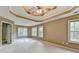 Spacious main bedroom with a decorative tray ceiling, ceiling fan, and large windows at 4845 Dartford Dr, Powder Springs, GA 30127