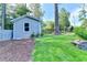 Backyard outbuilding with siding and landscaping, surrounded by a lush lawn and mature trees at 4845 Dartford Dr, Powder Springs, GA 30127