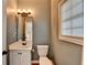 Updated powder room featuring a sleek vanity, mirror, modern lighting, and a window at 4845 Dartford Dr, Powder Springs, GA 30127
