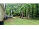 View of a spacious backyard with a wooden deck and mature trees, offering a private outdoor space at 4927 Millstone Walk, Stone Mountain, GA 30088
