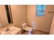 Bathroom featuring a vanity with a sink, a toilet, and a window, creating a functional and well-lit space at 4927 Millstone Walk, Stone Mountain, GA 30088