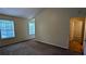Bedroom with neutral walls, carpet floors, two windows, and a connecting bathroom, offering a bright and serene space at 4927 Millstone Walk, Stone Mountain, GA 30088