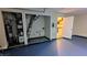 A garage with blue painted floors, mechanical components, and access to a kitchen, offering convenience and functionality at 4927 Millstone Walk, Stone Mountain, GA 30088