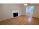 Bright living room with hardwood floors, a fireplace, ceiling fan, and a view into the dining area at 4927 Millstone Walk, Stone Mountain, GA 30088