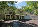 Rear exterior of home with balconies and covered patios, surrounded by mature trees and lush landscaping at 508 Hastings Dr, Peachtree City, GA 30269