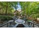 A backyard fire pit with outdoor seating surrounded by beautiful landscaping and mature trees at 508 Hastings Dr, Peachtree City, GA 30269