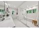 Bright bathroom featuring a glass shower with bench, double marble vanity, and view to the outdoors through two windows at 508 Hastings Dr, Peachtree City, GA 30269