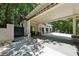 View of side carport entry and driveway framed by trees and landscaping at 508 Hastings Dr, Peachtree City, GA 30269
