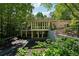 Rear exterior of home with balconies and covered patios, surrounded by mature trees and lush landscaping at 508 Hastings Dr, Peachtree City, GA 30269