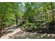 Scenic view of two homes on a tree-lined property with a winding driveway and manicured landscaping at 508 Hastings Dr, Peachtree City, GA 30269