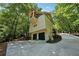 Unique home design with a garage, multiple balconies, and a winding driveway surrounded by lush trees at 508 Hastings Dr, Peachtree City, GA 30269