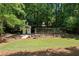 Backyard grounds feature a charming building with a birdcage and wooden bridge in a lush, wooded setting at 508 Hastings Dr, Peachtree City, GA 30269