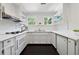 Bright, all-white kitchen features modern appliances and ample storage space with open shelving at 508 Hastings Dr, Peachtree City, GA 30269