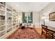 Bright home office with built-in bookshelves, hardwood floors, and a large window with wooded view at 508 Hastings Dr, Peachtree City, GA 30269