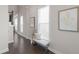 Light-filled hallway with wood floors, decorative art, and a cozy seating bench at 627 Skytop Dr, Cumming, GA 30040